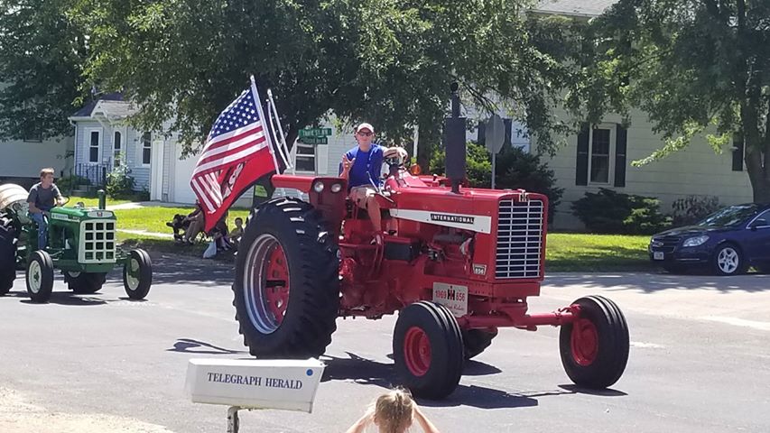 Micah driving his International Tractor in a parade